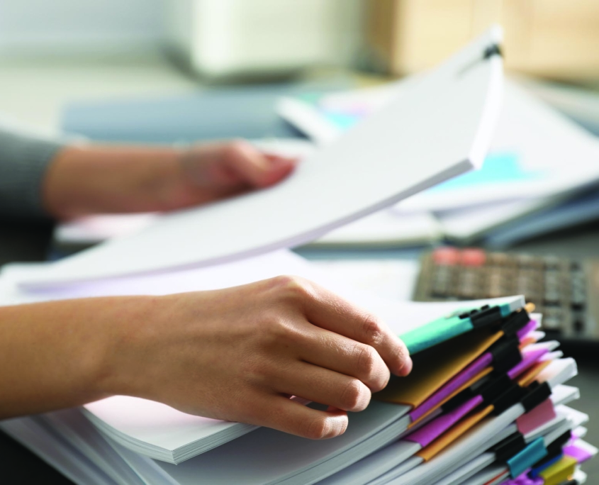 Close up view of person sorting through insurance policy documents