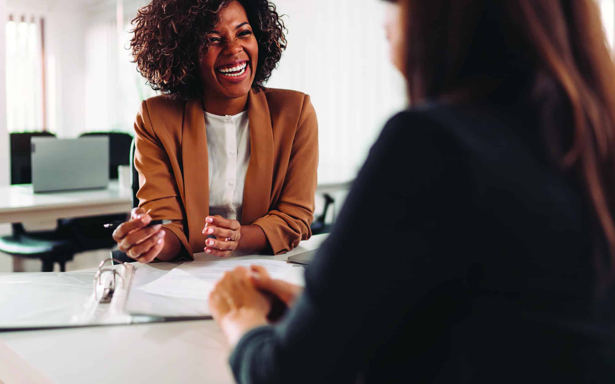 Smiling woman discusses a claim with her insurance agent