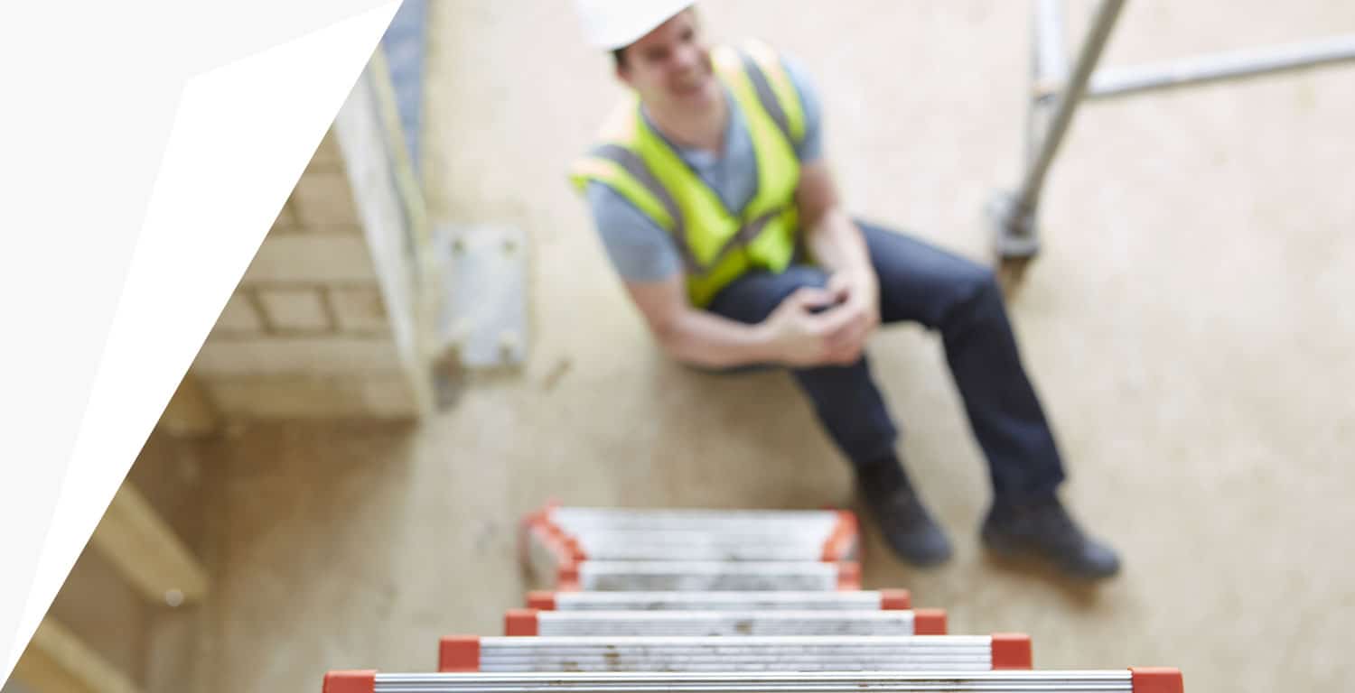 bird's eye view of injured construction worker holding knee after job injury