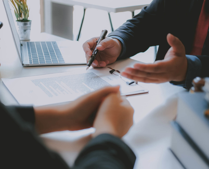 close up view of person going over document on clipboard with two clients