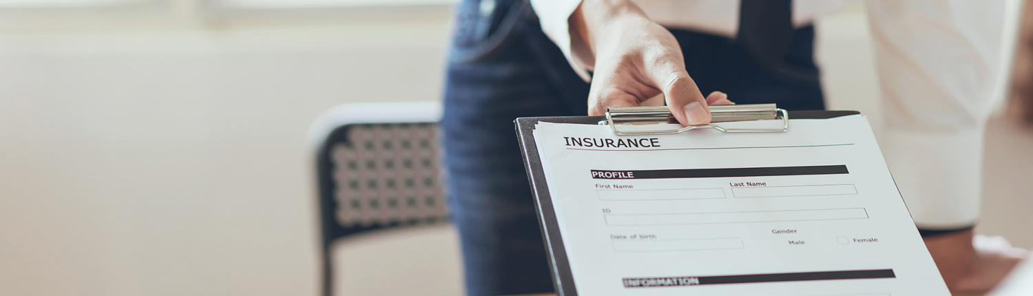 close up view of man handing a client an insurance form