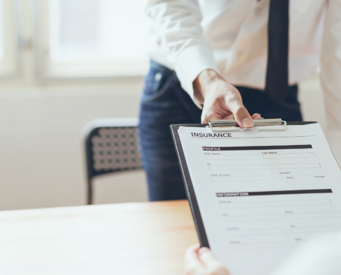 close up view of man handing a client an insurance form