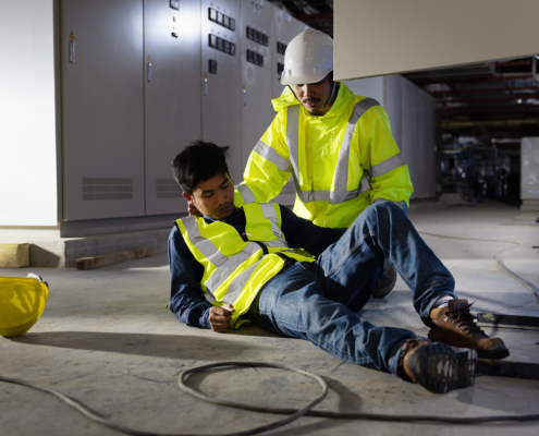 construction worker supporting injured coworker after a fall