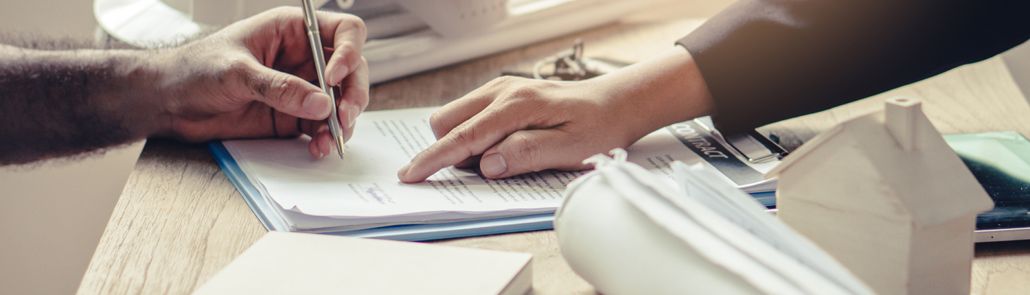 close up image of construction project manager pointing out where a client should sign a contract