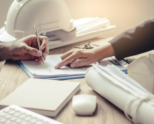 close up image of construction project manager pointing out where a client should sign a contract