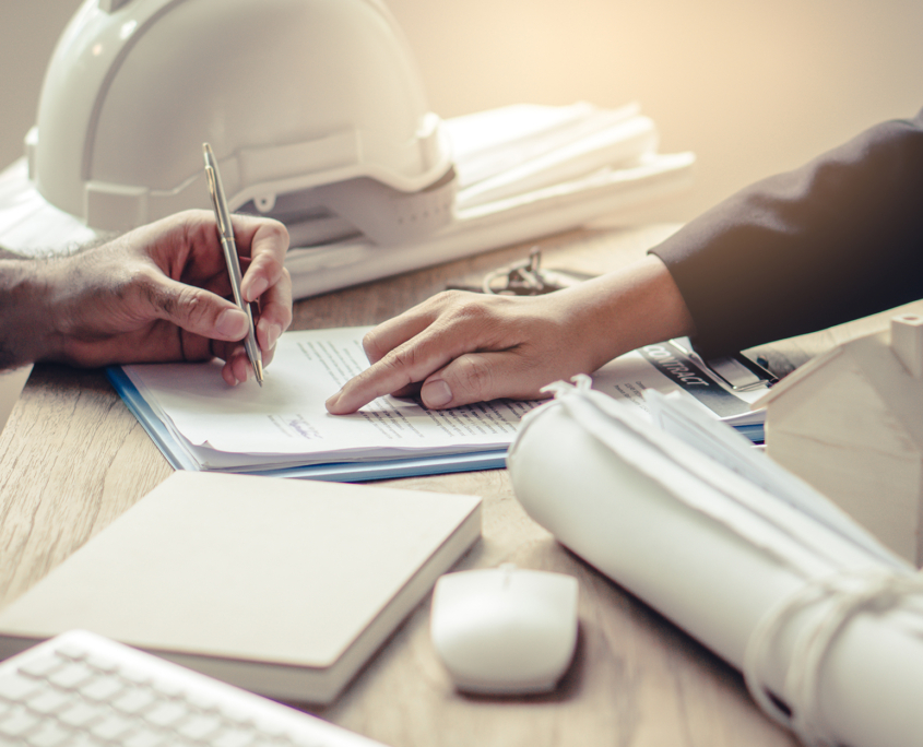 close up image of construction project manager pointing out where a client should sign a contract