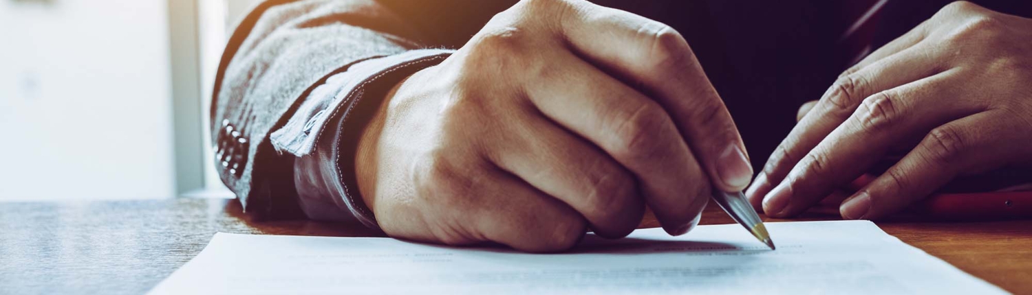 close up of a person signing a document_