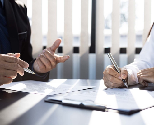 salesman and the customer are signing an insurance agreement with their insurance